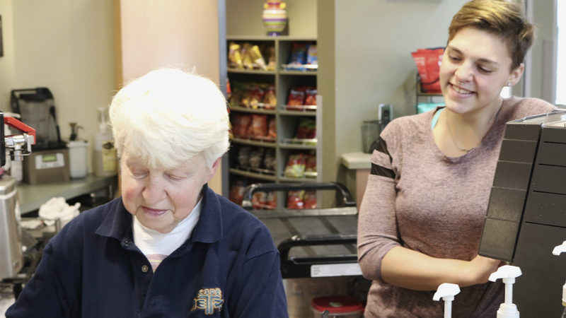 Student smiles as campus favorite barista prepares coffee