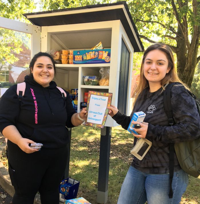 Two students standing in front of the little food pantry
