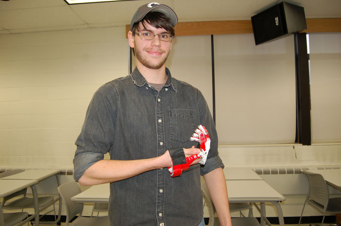 student holding prosthetic hand