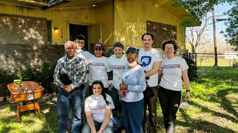 A group of Penn State Behrend students stand with the owners of a Houston home damaged by Hurricane Harvey.