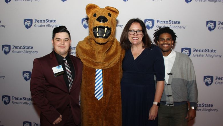 Lion mascot with students and Greater Allegheny chancellor 