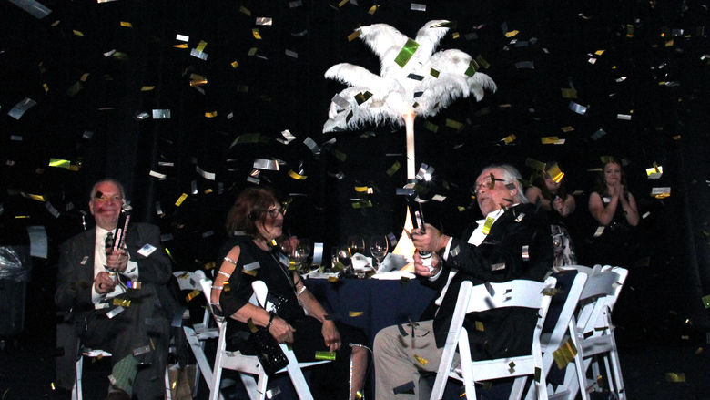 people sitting at a table with a confetti paper 