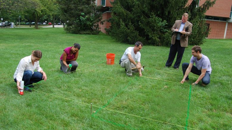 people measuring a garden