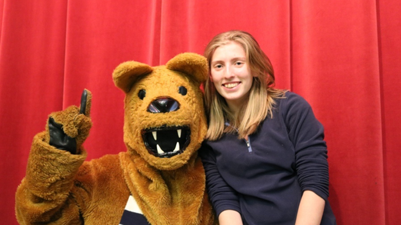 Penn State Nittany Lion Mascot making a number 1 with hand posing with a student 