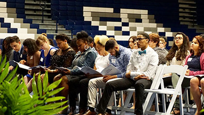 students sitting in chairs reading program