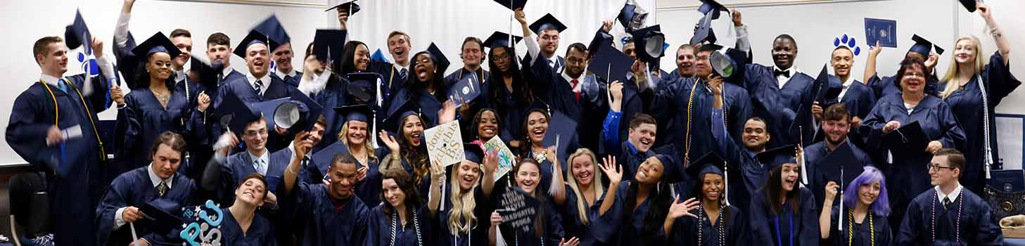 Graduates holding up their caps