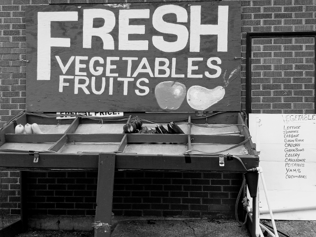 Produce stand with a sign that reads Fresh Vegetables Fruits