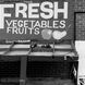 Produce stand with a sign that reads Fresh Vegetables Fruits