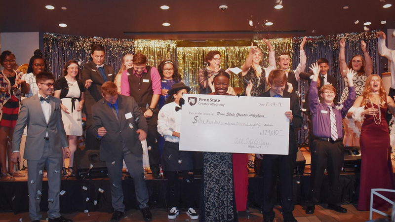 Students reveal donation total at 2017's All That’s Jazz scholarship benefit. 