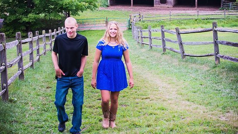 woman and man walking in field