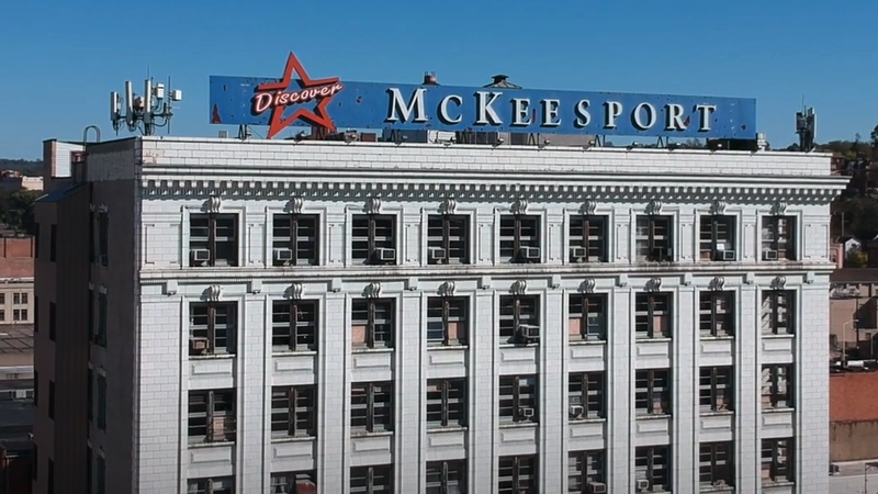 Building with a sign on the roof that reads Mckessport. 