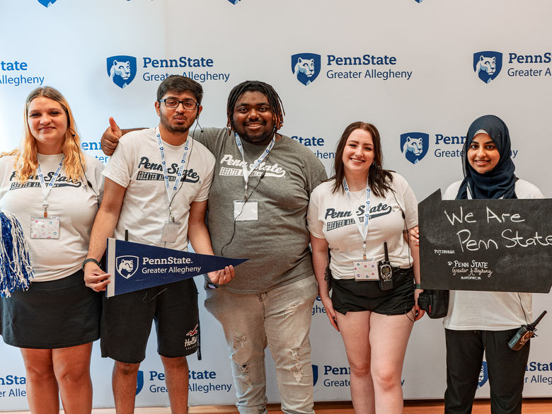 students posed for a photo holding Penn State items and wearing Penn State merchandise.