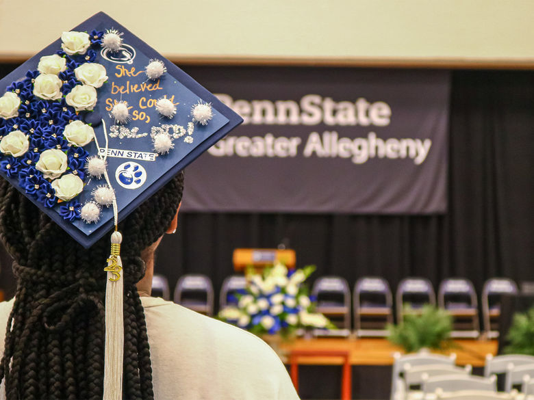 Back of students graduation cap looking at stage during a rehersal