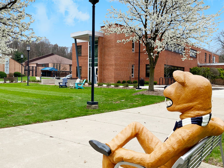 Nittany Lion sitting on a bench outside the Buck Family Lawn at Penn State Greater Allegheny
