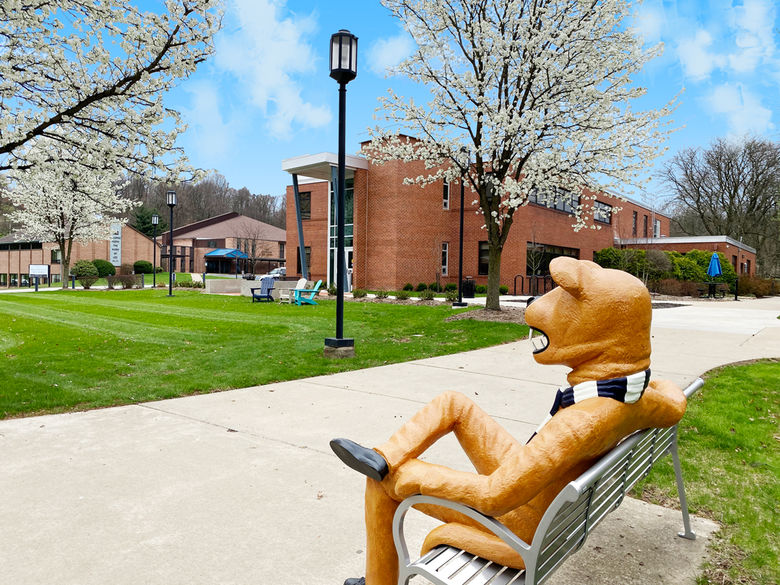 Nittany Lion sitting on a bench outside the Buck Family Lawn on Penn State Greater Allegheny's campus