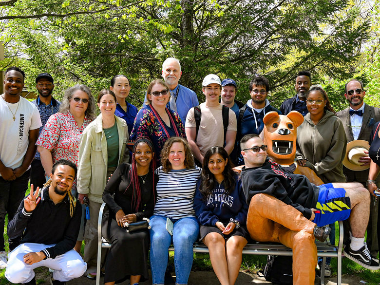 Group photo of the spring 2024 rising scholars with their faculty nominators surrounding the Nittany Lion statue that is sitting on a bench.