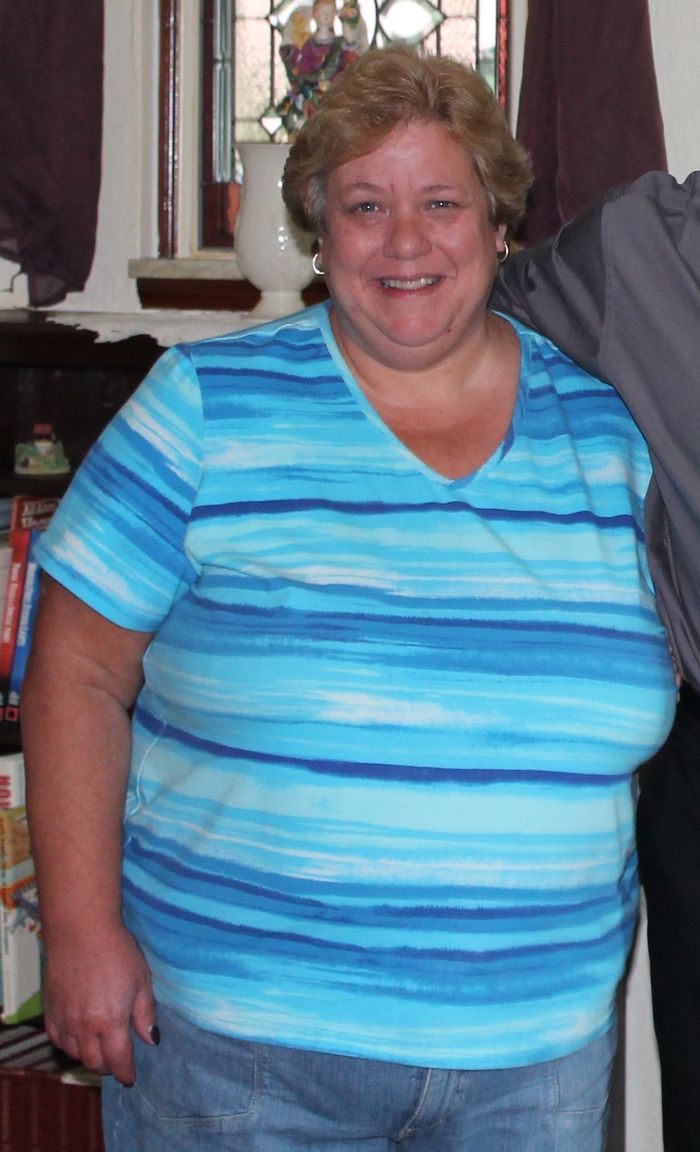 Photo of Colin's mother smiling wearing a multi colored strip shirt 