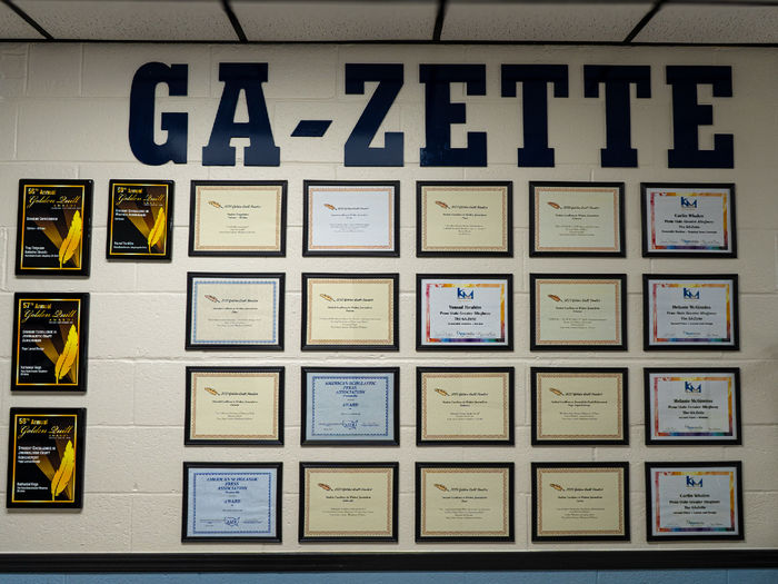 Award plaques and certificates hung on a wall