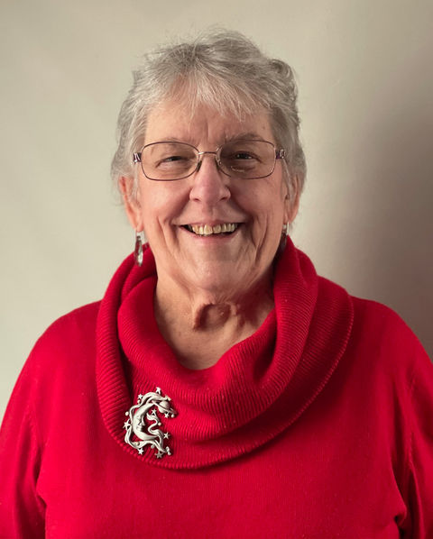 Image of woman smiling wearing a red sweater.