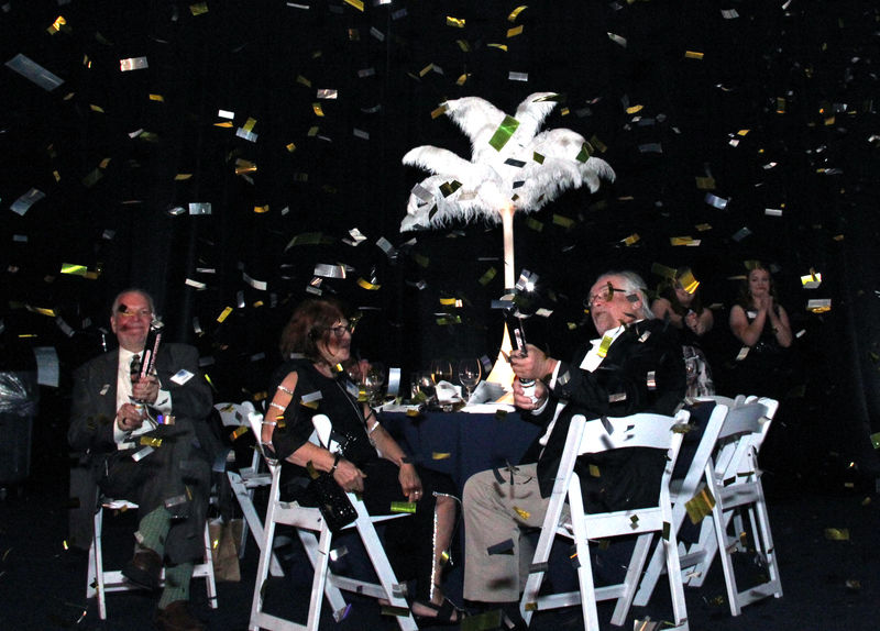 people sitting at a table with a confetti paper 