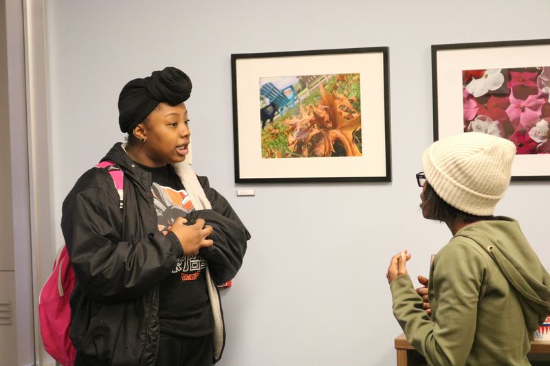 two students talking in front of picture