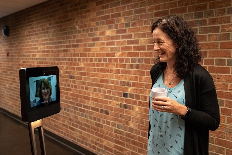 Kristal Tucker and Penelope Morrison interact via robot
