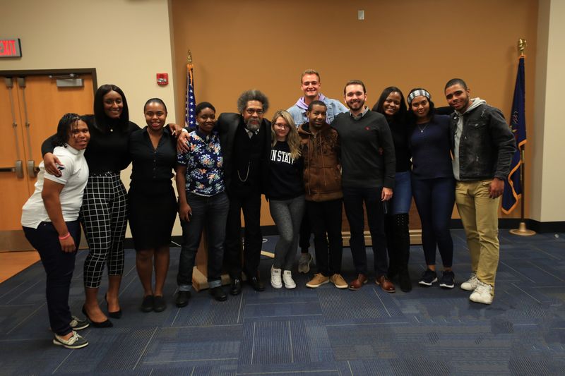a group of students standing next to Dr. Cornel West in the Ostermayer Room of the Student Community Center