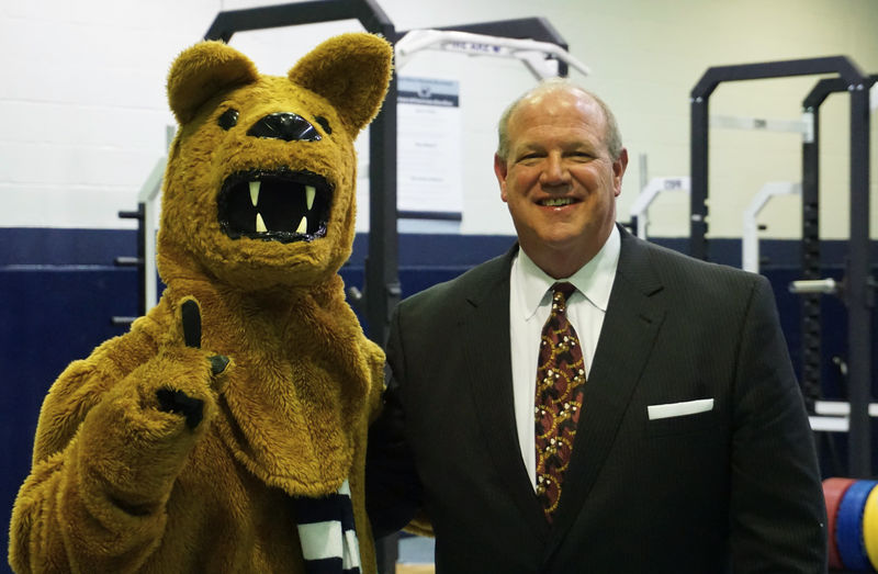Regis W Becker standing next to Nittany Lion mascot