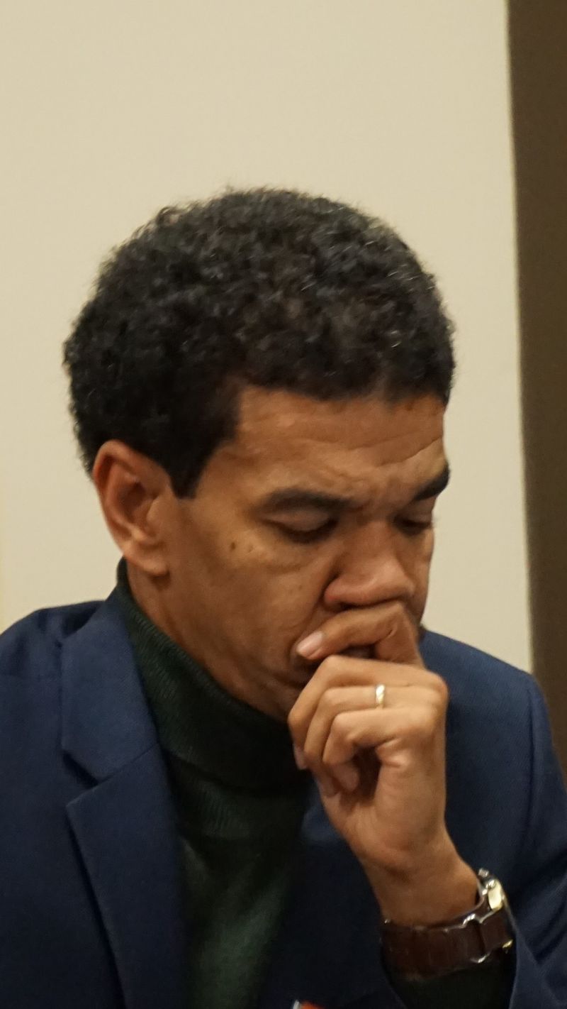man in deep thought with hand covering mouth and chin