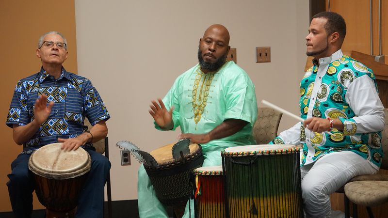 Three men playing African drums 