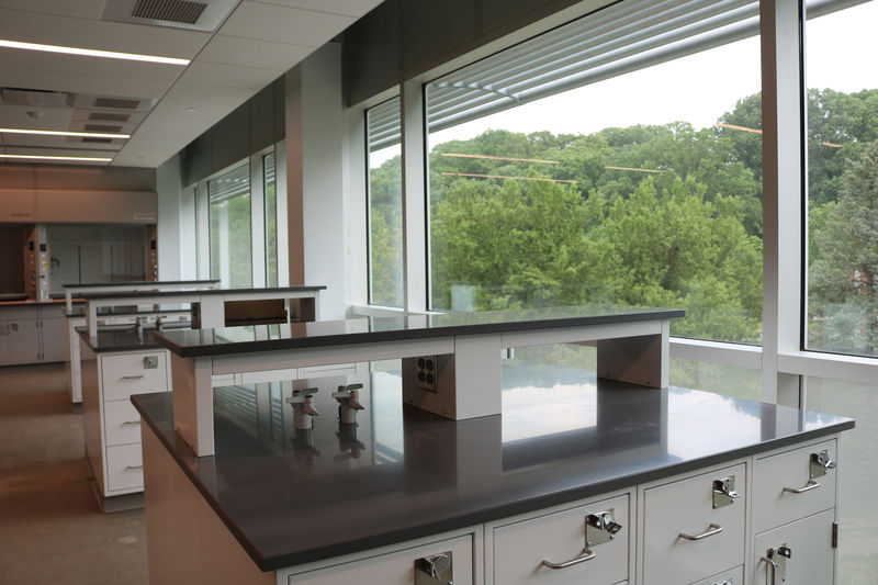 Lab space with tables and a wall of windows. 
