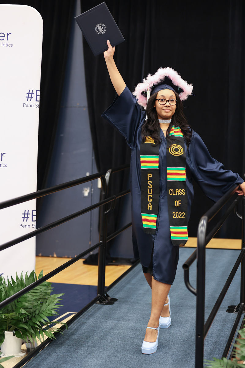 Psychology (B.S.) Degree Candidate Sueriah Om’Unique Timsah waves her diploma in the air