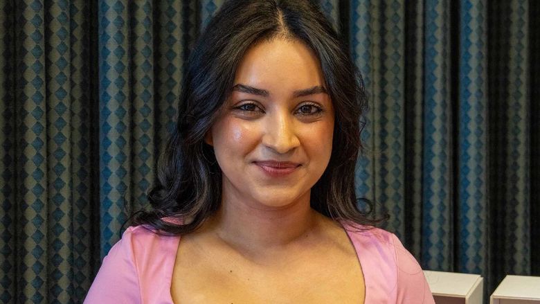 Tapashya Ghimirey smiles on stage at Penn State Greater Allegheny.