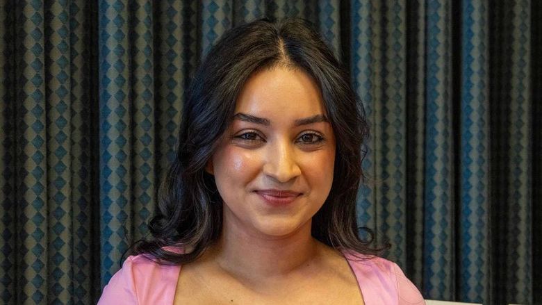 Tapashya Ghimirey smiles on stage at Penn State Greater Allegheny.