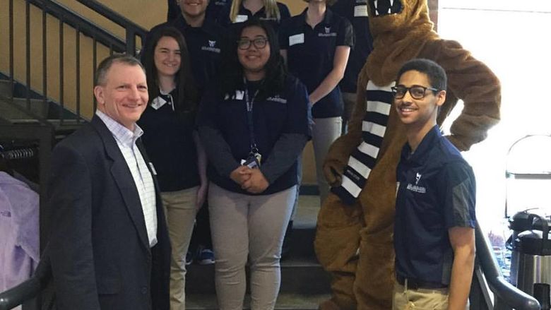 group of students pose with lion