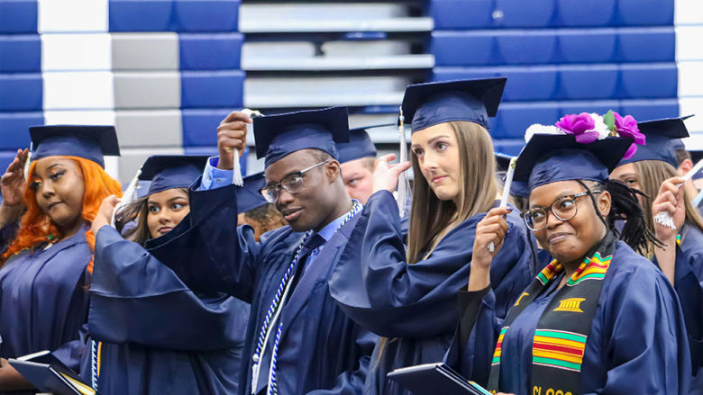 People in graduation caps moving their tassels