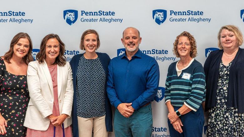 Group photo in front of a Penn State Greater Allegheny backdrop