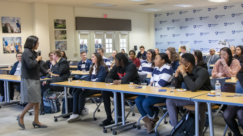 Woman with microphone speaks to classroom full of students