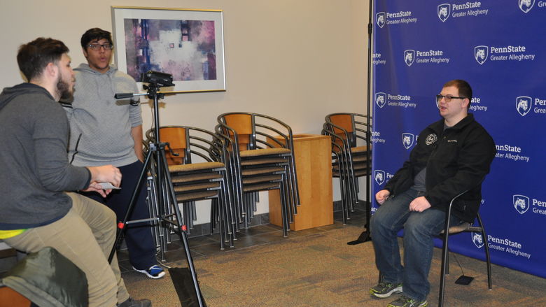 man being filmed sitting in chair
