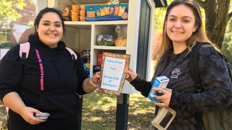 Two students standing in front of the little food pantry