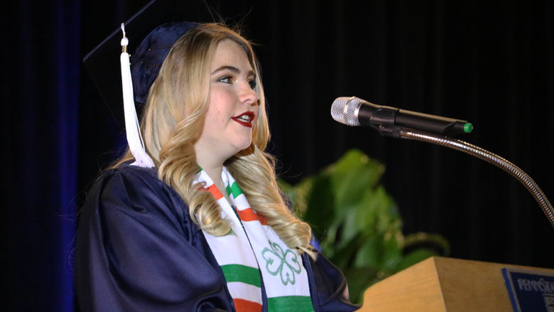 woman standing at podium speaking into microphone