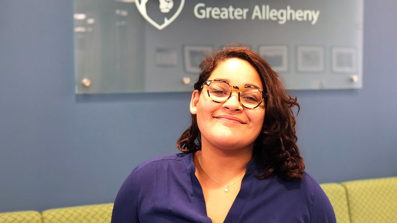 Exchange student Joyce Cabrera smiling in front of Penn State Greater Allegheny Logo 