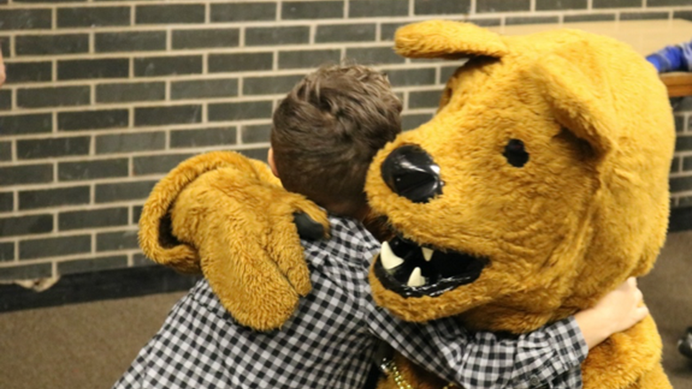 Nittany Lion Mascot giving hug to child 