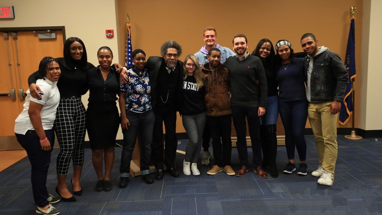 a group of students standing next to Dr. Cornel West in the Ostermayer Room of the Student Community Center