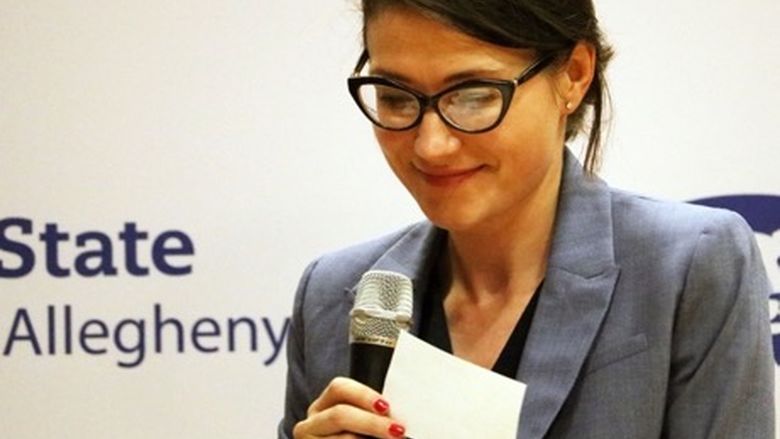 Women smiling reviewing note cards holding a microphone