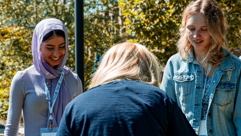 3 students laughing as they play games at their NSO session
