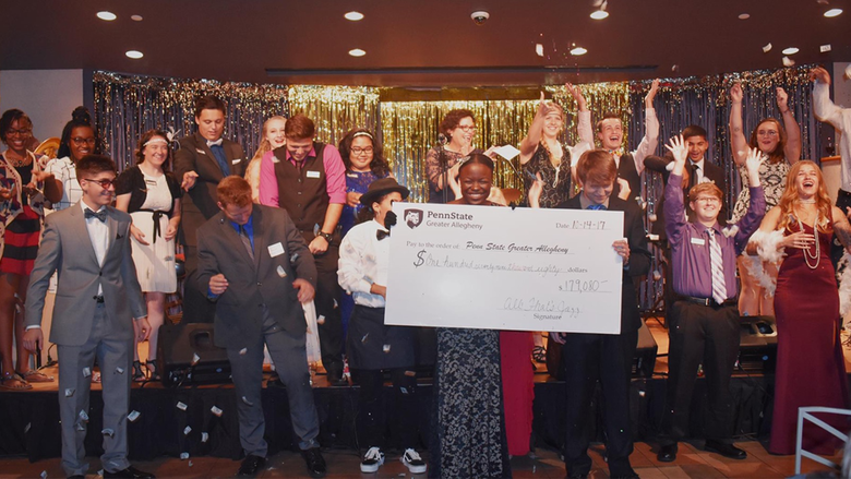 Students reveal donation total at 2017's All That’s Jazz scholarship benefit. 