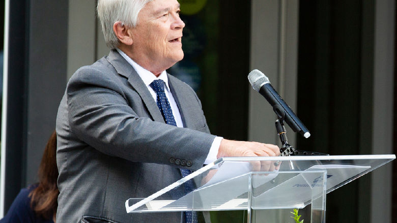 President Barron speaking at a podium into a microphone