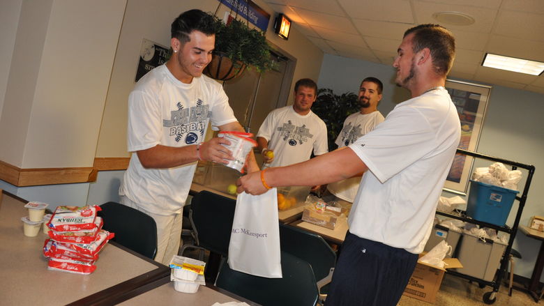 men help pack backpacks for kids