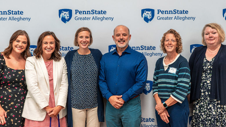 Group photo in front of a Penn State Greater Allegheny backdrop